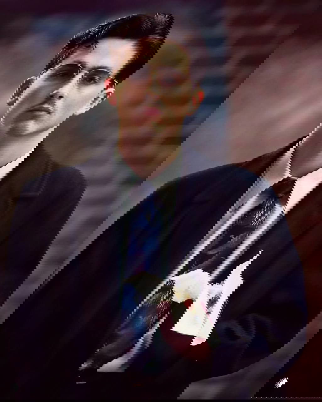 Крупный портрет мужчины в пиджаке и галстуке; акцент на аксессуарах и классическом крое, стилизованный образ в духе середины XX века.