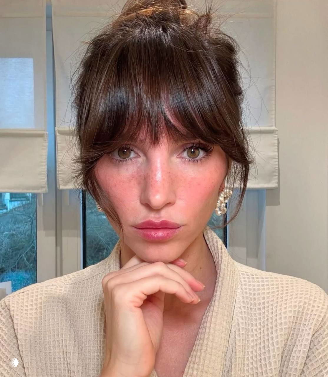 Портрет крупным планом: стрижка с рваной челкой, текстурированная челка и естественная укладка, лёгкий макияж в домашней обстановке.