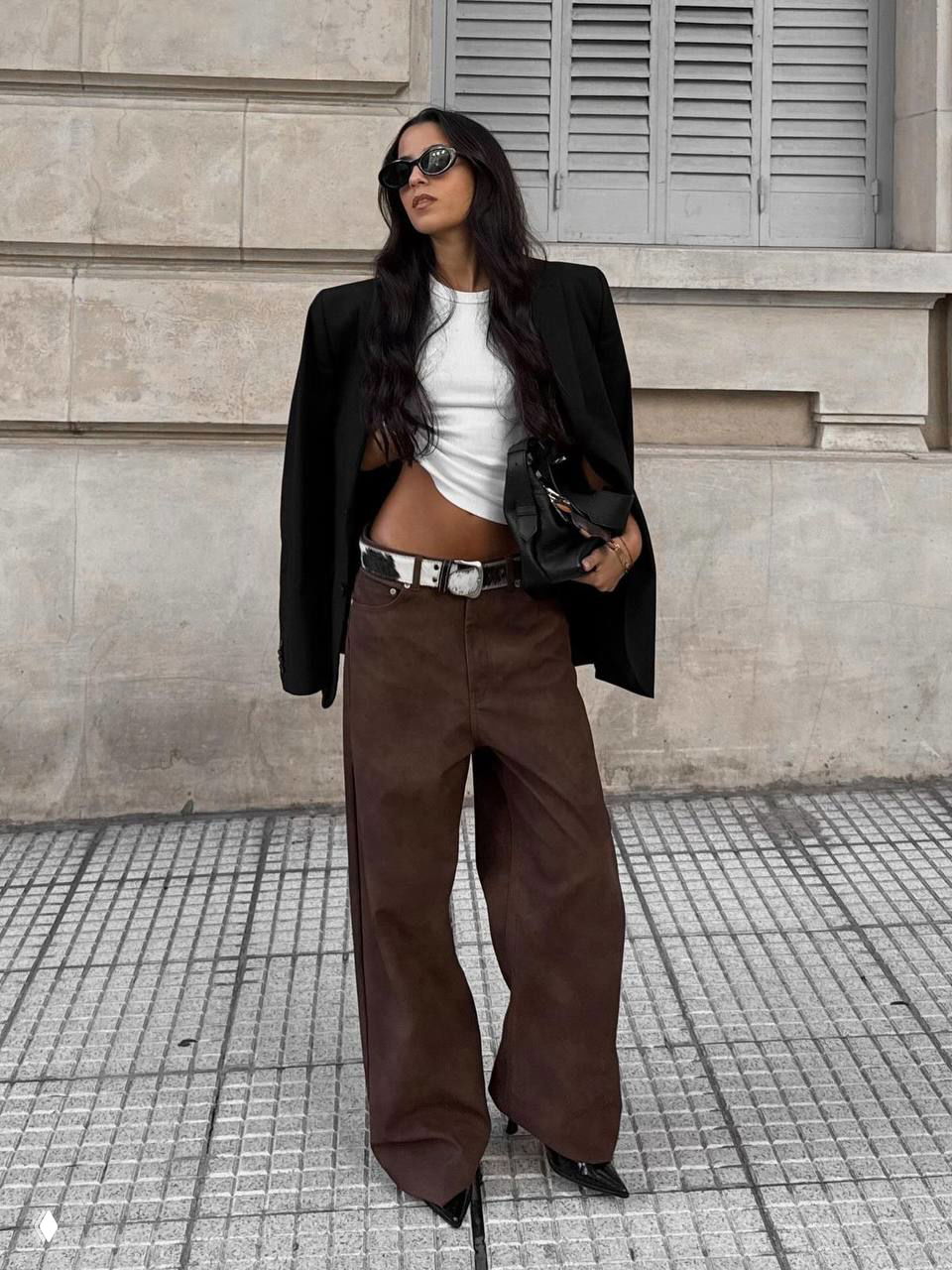 Модель в уличном кадре в широких коричневых брюках-джинсах с высоким поясом и прямым силуэтом, образ в стиле smart-casual.