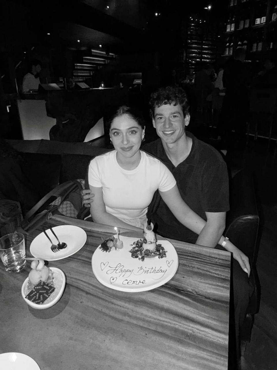 Джемре и Джем сидят за столом в ресторане с десертной тарелкой «Happy Birthday», пара улыбается; видны столовые приборы и бокал воды.
