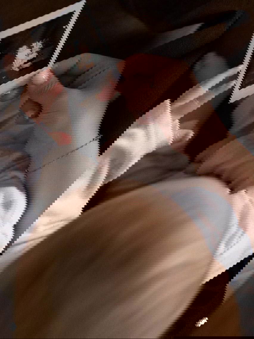 Руки мамы удерживают полароидную фотографию, которую рассматривает малыш; кадр подчёркивает семейные воспоминания и нежную атмосферу дома.