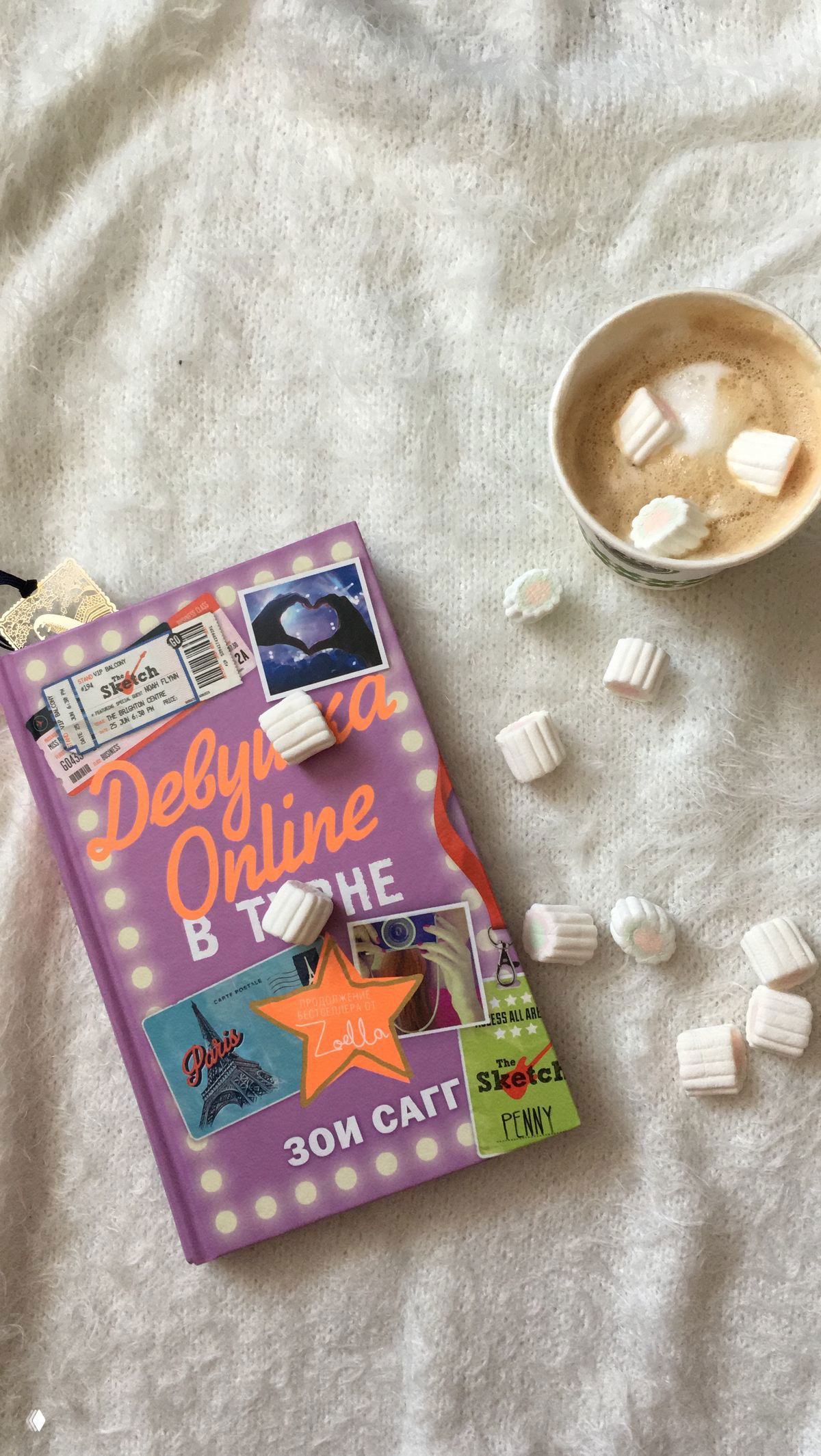 Фиолетовая обложка книги «Девушка Online» Зои Сагг на пледе рядом с чашкой кофе и зефирками — эстетичное фото книги и аксессуаров для чтения.