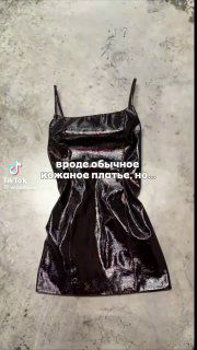 Чёрное лаковое платье выложено на полу: видно блеск и форму; на кадре подчёркнуто, что при растяжении материал меняет цвет на красный.