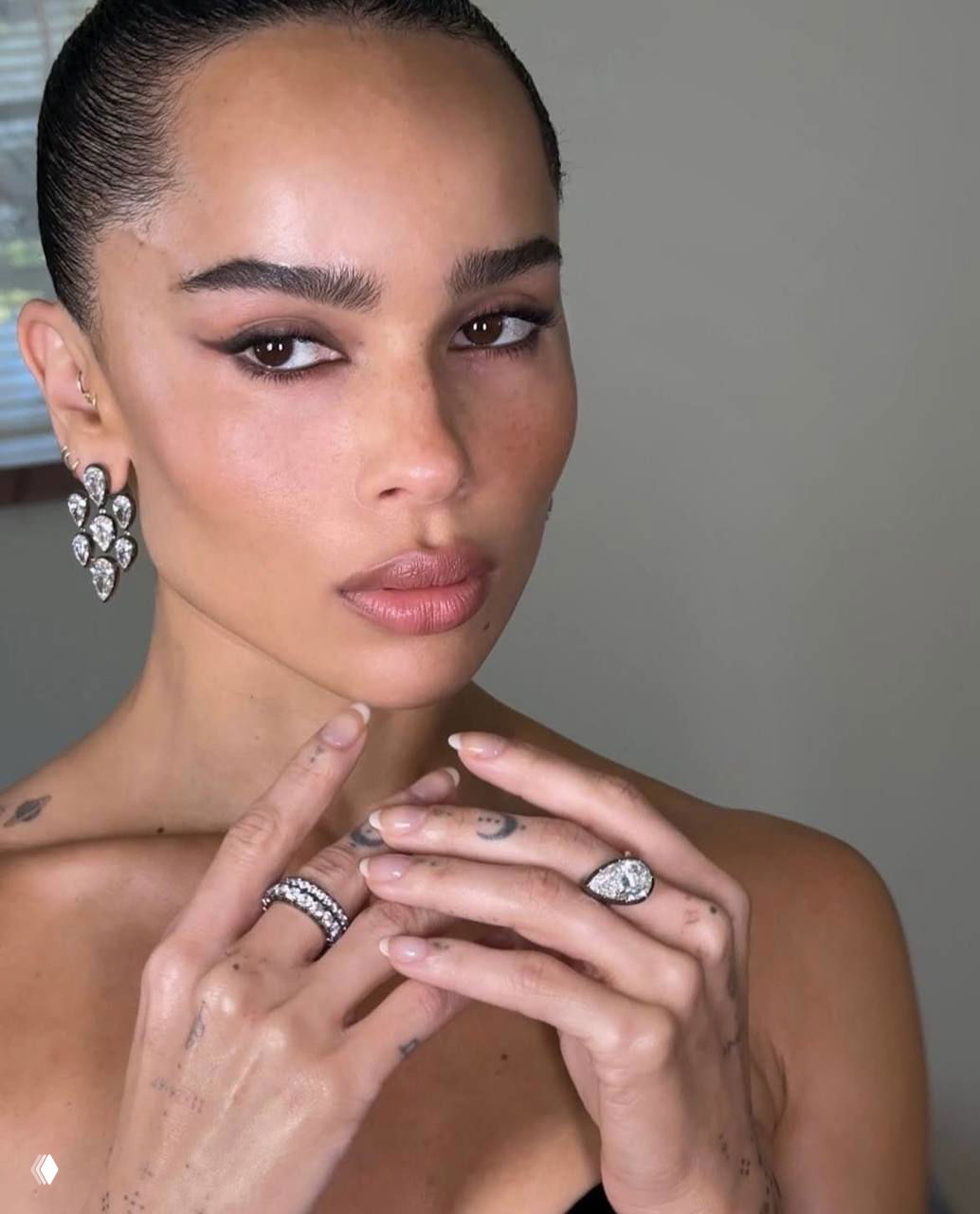 Близкий портрет женщины с гладкой кожей и выразительными глазами; акцент на черные растушеванные стрелки, длинные ресницы и нежный нюдовый тон губ.