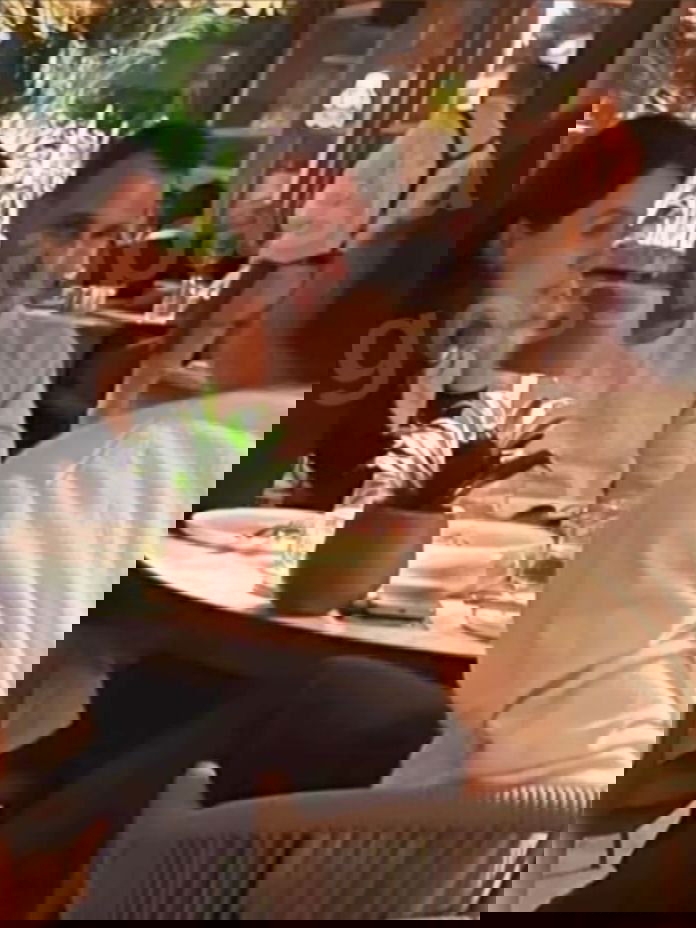 Снимок из аккаунта Gossip Pasta: Керем Бюрсин за столом в ресторане во время ужина в компании, на фото виден водяной знак источника.