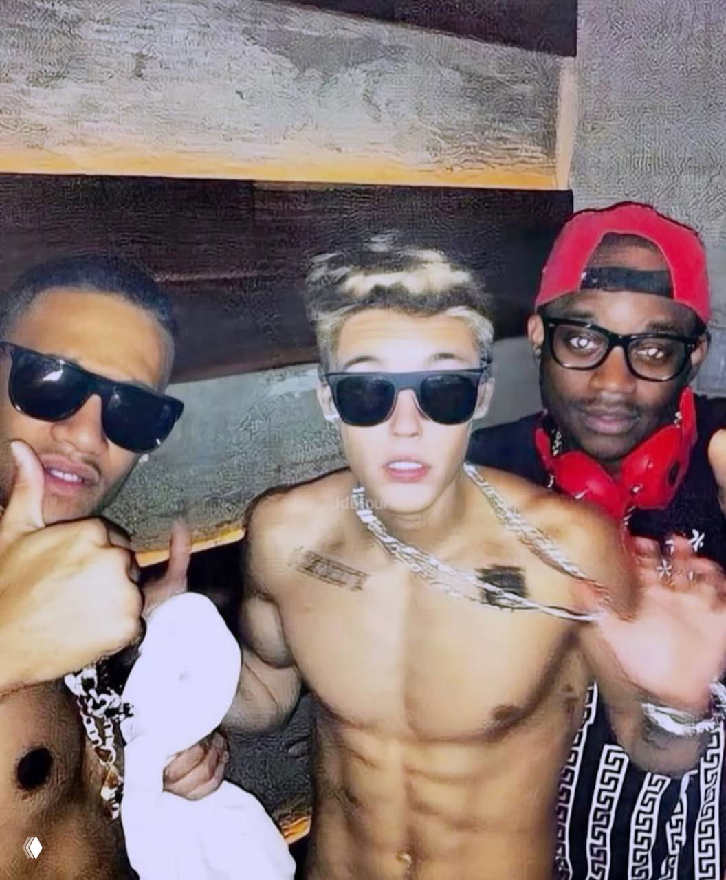 Групповой снимок в клубе: молодой человек без рубашки в солнцезащитных очках и друзья, яркая ночная атмосфера и цепочки на шее.