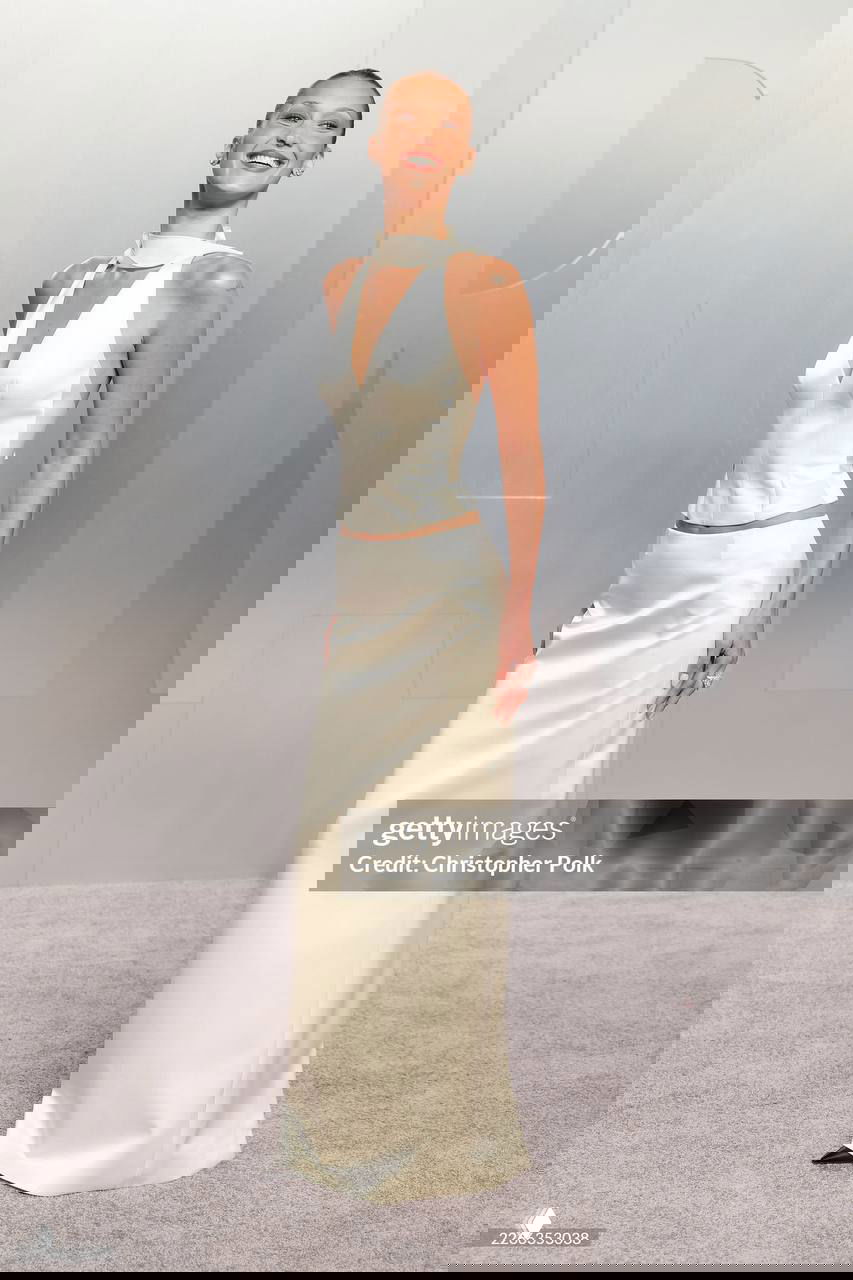 Модель в лаконичном кремово‑белом платье с вырезом и открытой талией стоит на ковровой дорожке афтепати Vanity Fair.