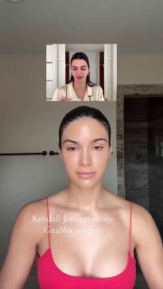 Вертикальный кадр из видео‑туториала: женщина демонстрирует технику гуаши на лице в ванной комнате, видна верхняя часть туловища и интерьер.