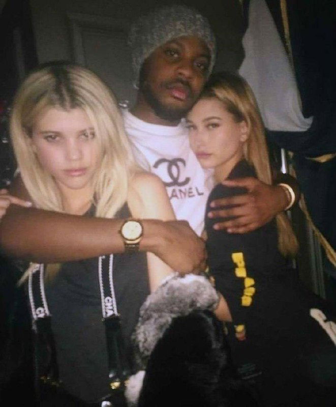 Три человека в тёплых цветах на кадре: объятия, нейтральные лица и приглушённое освещение в стиле 2010-х клубных фото.