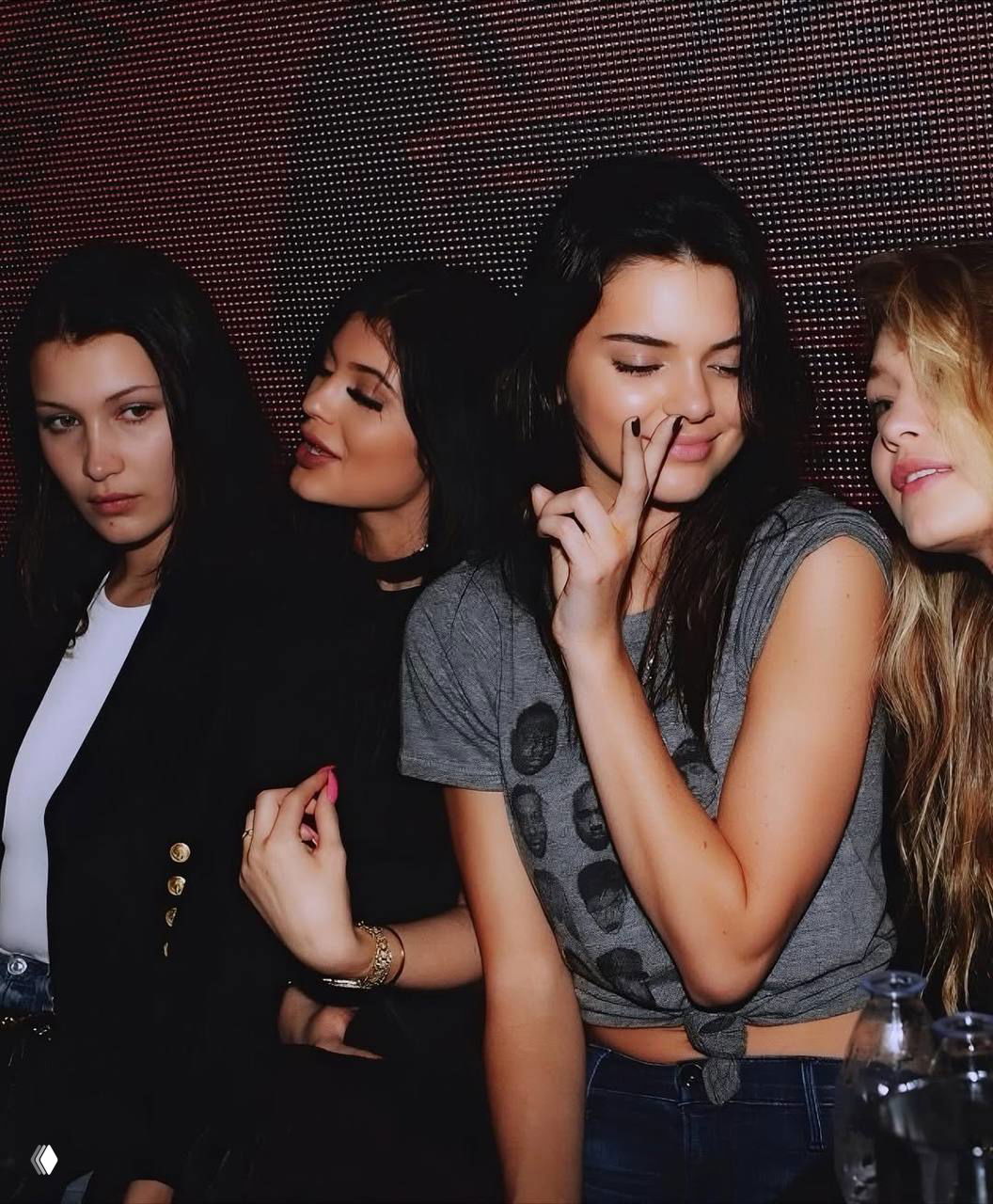 Группа девушек в клубе: плотная посадка в кадре, лёгкие жесты руками и полумрак сцены, снимок перед танцами вечеринки.