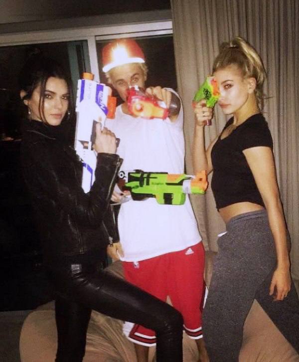 Пара молодых людей с игрушечными бластерами и лёгким флиртом в кадре, домашняя вечеринка с шутливой динамикой и свободным настроением.