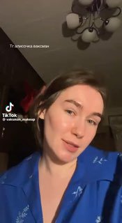 Крупный план женщины в домашней обстановке во время записи TikTok‑видео; мягкое дневное освещение, фокус на лице.