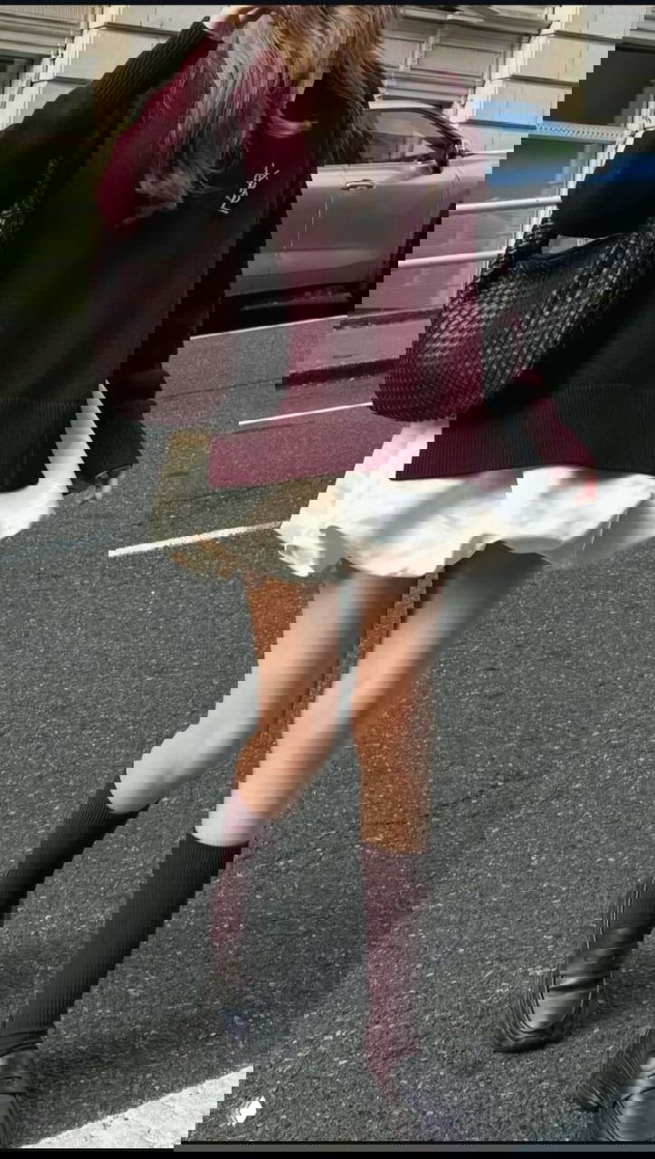 Низ тела: бордовый свитер и молочная пышная мини-юбка, бордовые гольфы и лоферы на асфальте осеннего города.