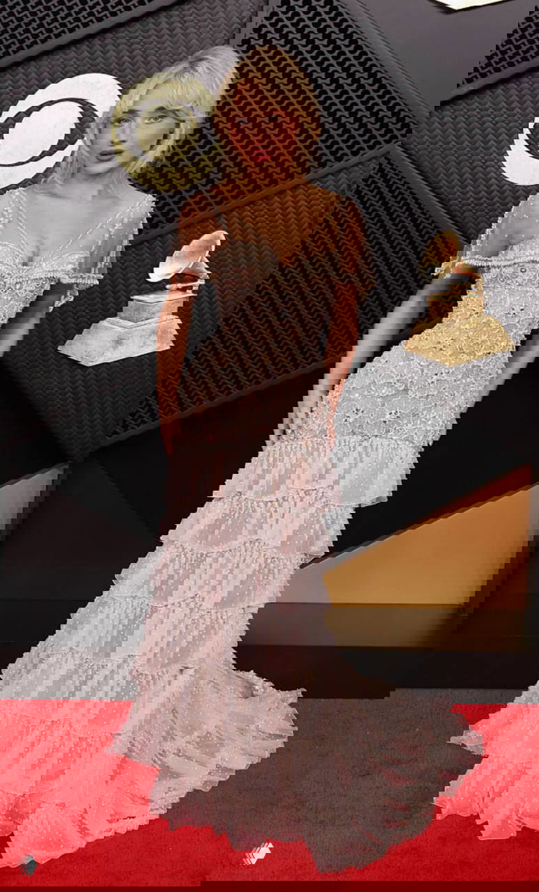 Сабрина Карпентер на красной дорожке «Грэмми» в светлом многоярусном платье Valentino; кружево, вышивка и нежный романтический образ.