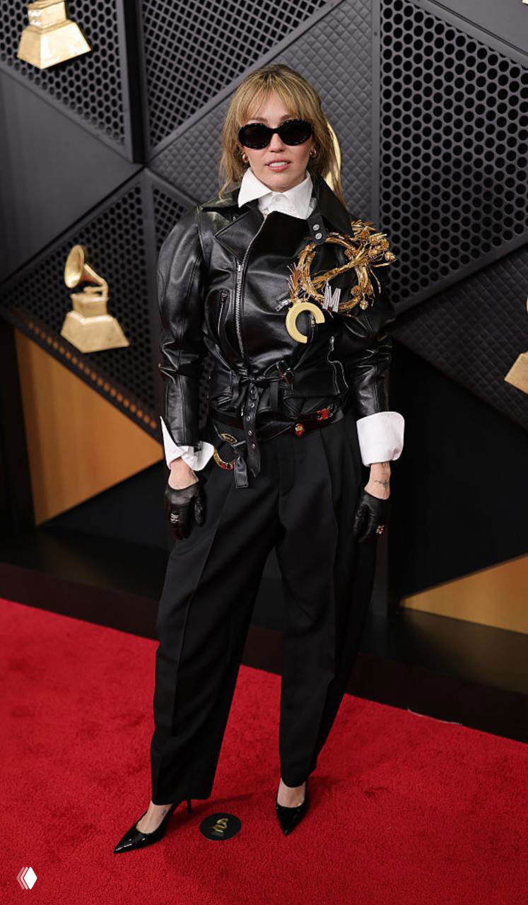 Майли Сайрус на красной дорожке «Грэмми» в чёрной кожаной куртке Celine; спокойный рок-стиль с очками и строгими деталями.