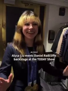 Короткое видео/скриншот за кулисами: молодая спортсменка с медалями, виден фрагмент субтитров и обстановка закулисья.