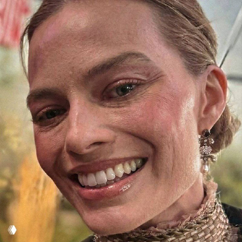 Крупный искажённый фрагмент фотографии лица Марго Робби с улыбкой, наложенные цветовые артефакты и искажения