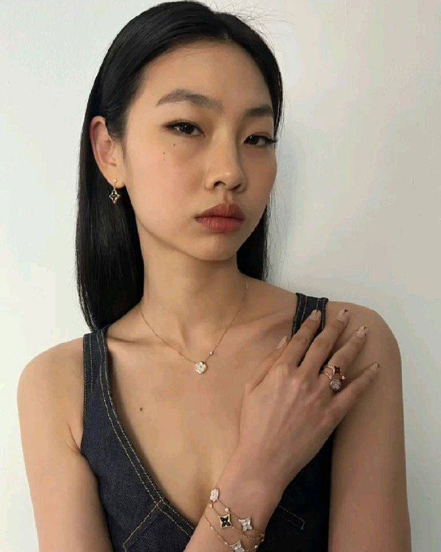 Портрет женщины в топе с украшениями; крупный план шеи и руки, чёткая кожа и ювелирные детали на руке и шее.