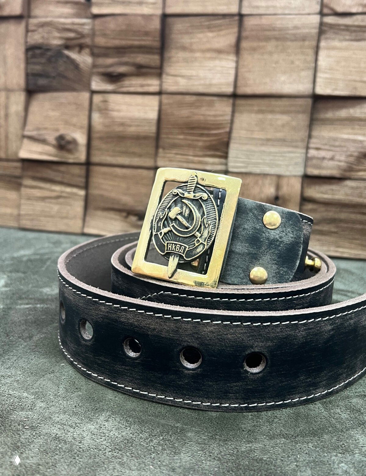 Чёрно‑серый состаренный кожаный ремень с широкой полосой и массивной пряжкой с орнаментом, фокус на текстуре кожи и отверстиях.