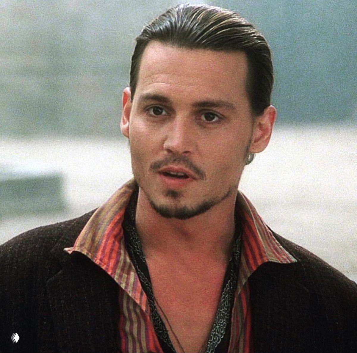 Крупный план мужчины в повседневной одежде у воды — кадр из мелодраматической экранизации с естественным освещением.