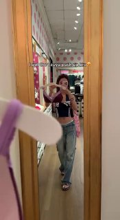 Зеркальное селфи в магазине: пример примерки белья и образа в стиле K-pop; видно продавец/примерочная обстановка и предметы в интерьере магазина.