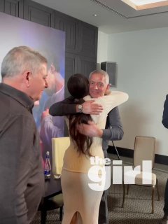 Кадр с пресс‑подхода: Ханде Эрчел обнимает другого продюсера на фоне баннера фильма «Два мира, одно желание» в московской пресс‑комнате.