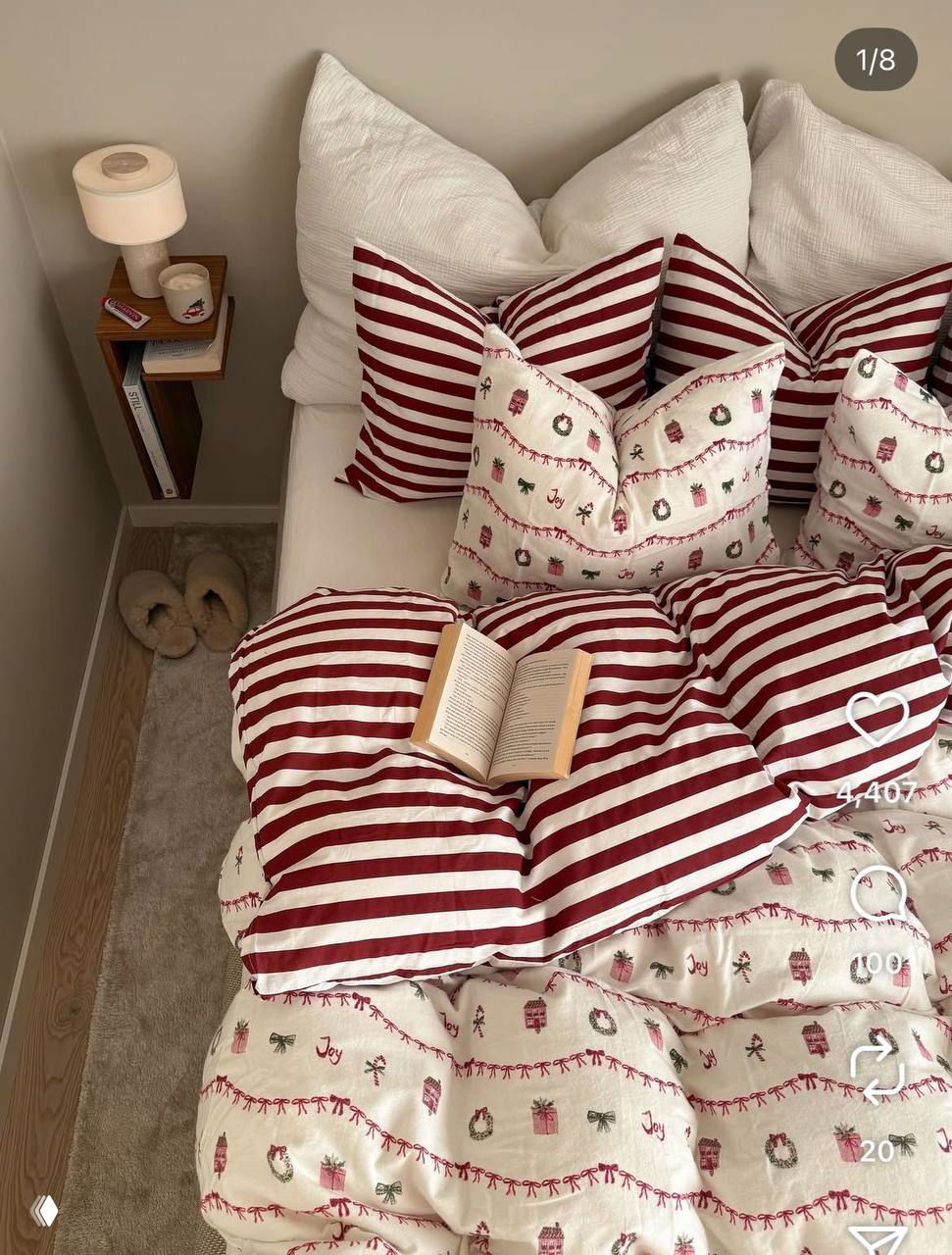 Кровать с красно-белым постельным комплектом в рождественском стиле и открытая книга на одеяле — уютный интерьер для праздников.