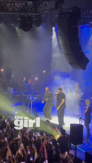 Эмре Алтуг на сцене московского сольника: певец и бэнд в свете прожекторов, зрители с телефонами снимают момент