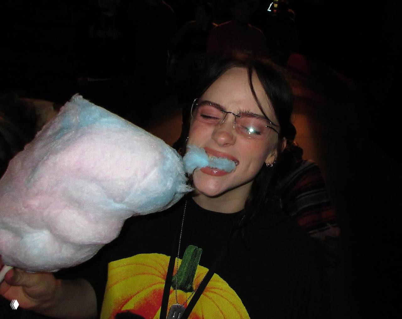 Крупный план: девушка пробует сладкую вату, улыбка и закрытые глаза, тёплое свечение и ощущение уютного октябрьского вечера.