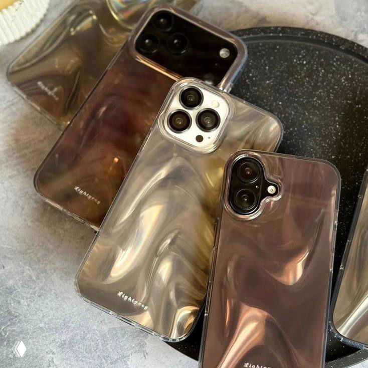 Несколько смартфонов в прозрачных чехлах на поверхности — аксессуары и блеск как элемент повседневной эстетики и праздничных мелочей.