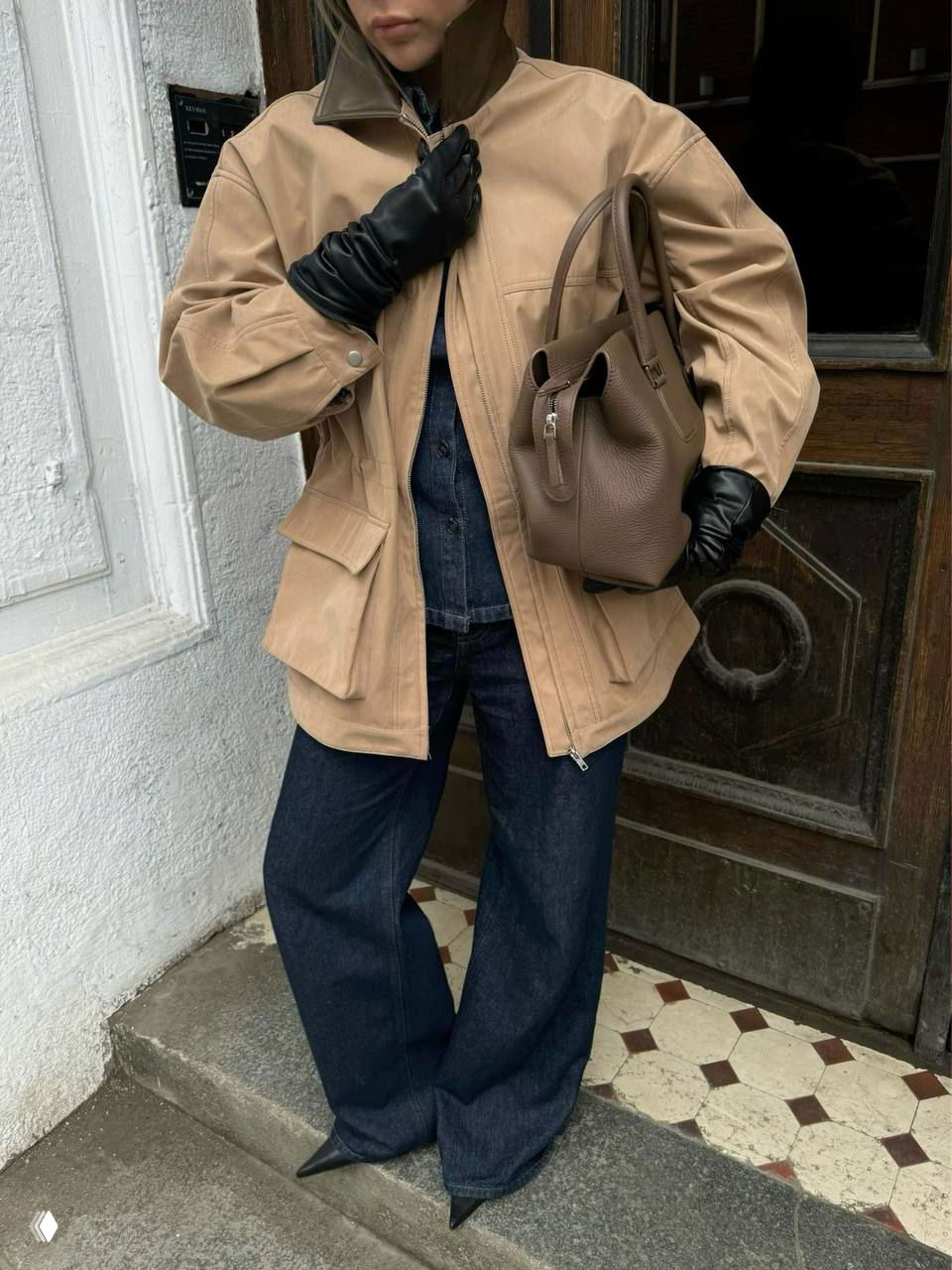 Бежевая утилитарная куртка с накладными карманами и чёрными кожаными перчатками, образ с тёмными широкими джинсами и вместительной сумкой.