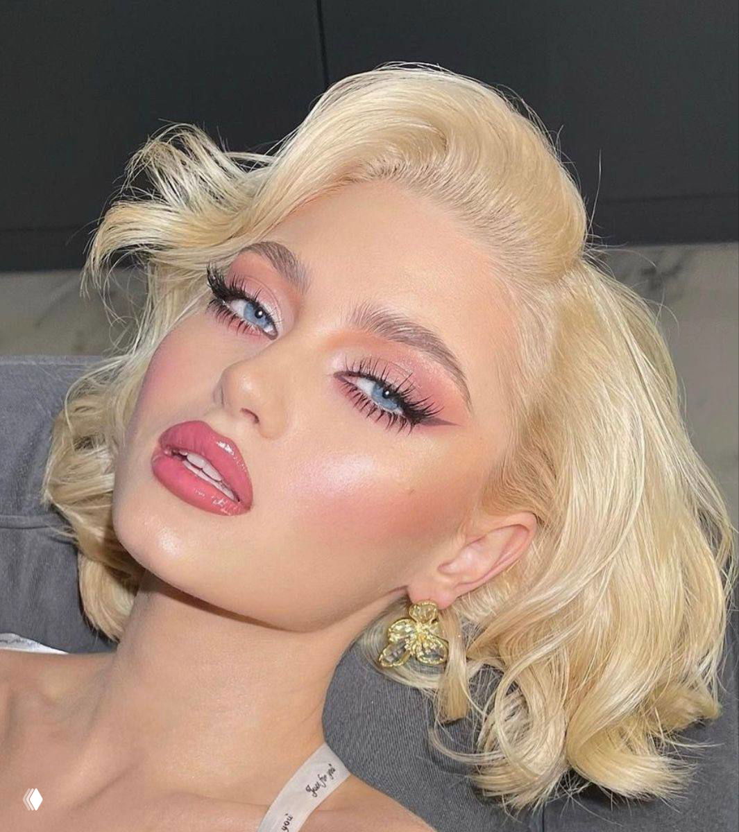 Модель в гламурном образе с розовым макияжем глаз, выраженным румянцем и ярко-розовой губной помадой — вариант для праздничного выхода на 14 февраля.