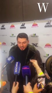 BLOK3 во время пресс-подхода: артист отвечает журналистам, в кадре несколько микрофонов, телефоны и фон с логотипами