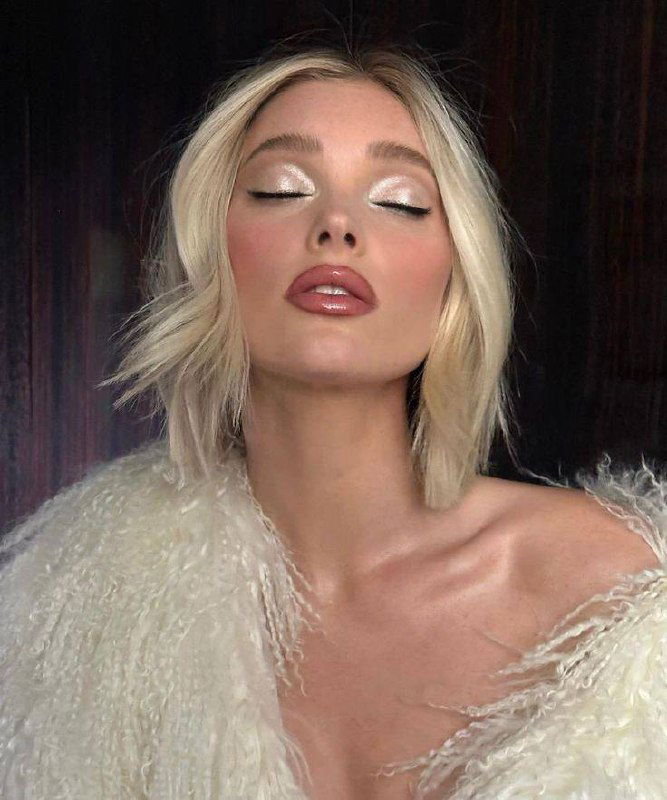 Портрет блондинки с закрытыми глазами и ярким серебристым шиммером на веках, натуральный тон кожи и нюдовый блеск губ.