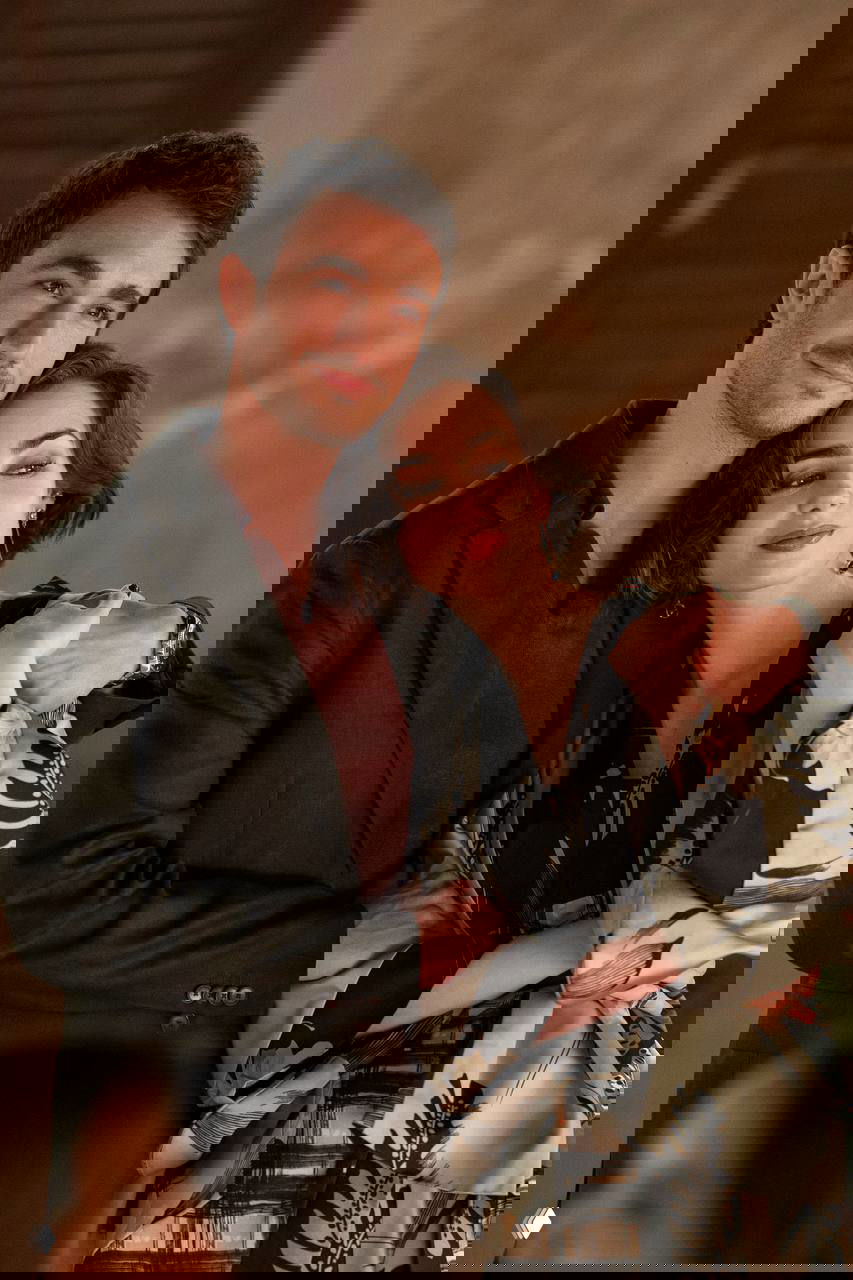 Сцена в интерьере: героиня и мужчина обнимаются, она в легком платье с принтом и крупными серьгами, мягкое теплое освещение.