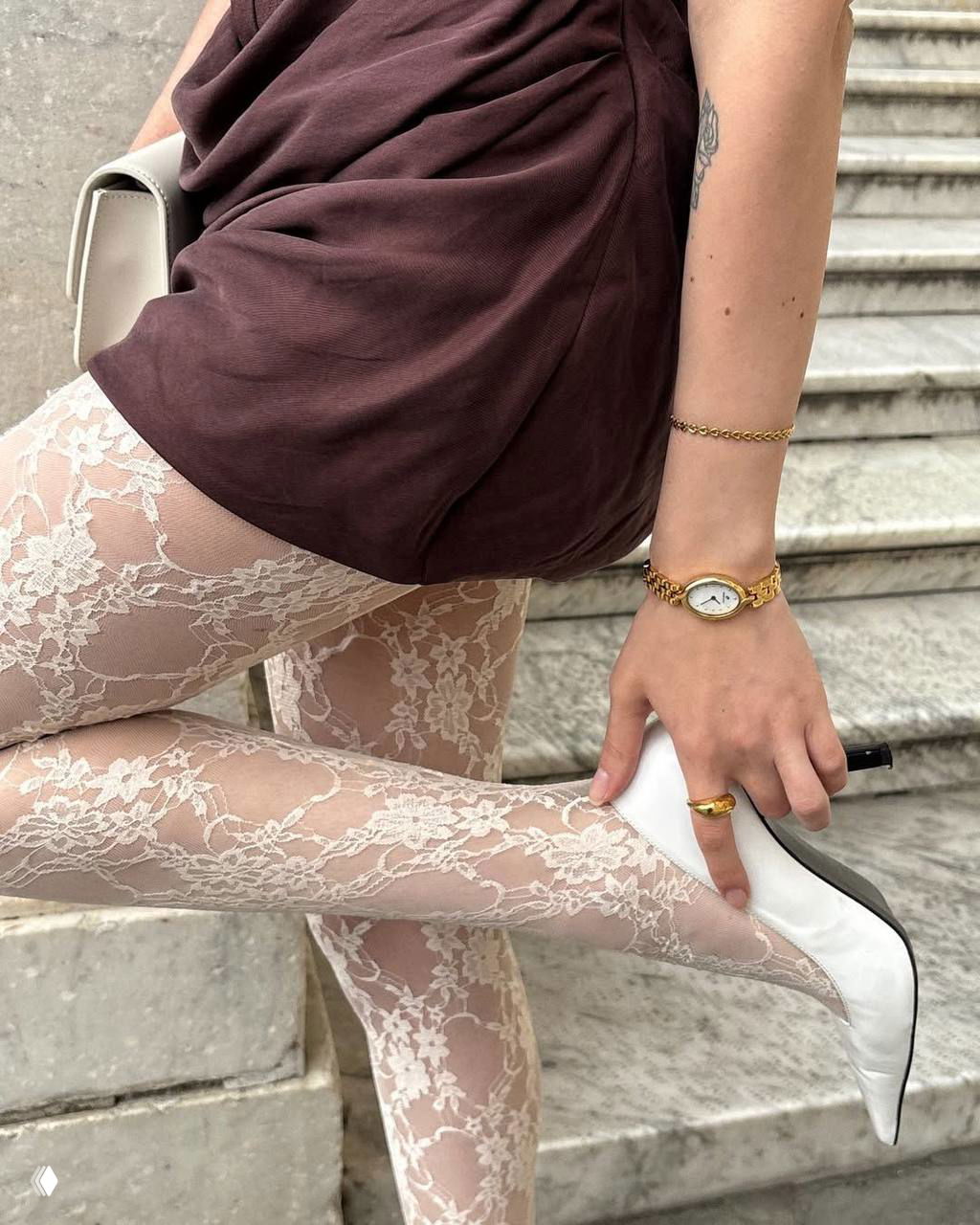 Низ образа: белые кружевные колготки, бордовая мини-юбка и белые туфли на каблуке — сочетание фактур и классики для эффектного праздника.