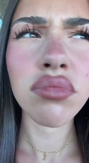 Крупный план лица молодой женщины с подчёркнутыми губами и накладными ресницами в вертикальном видео — фрагмент короткого клипа для социальных сетей.