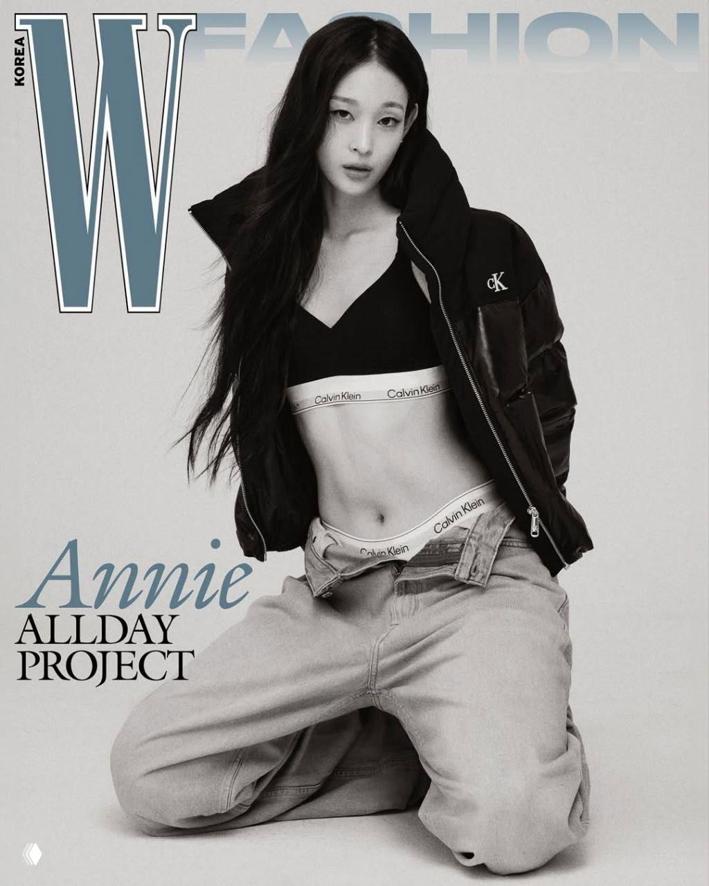 Чёрно‑белая фотосъёмка: участница ALLDAY PROJECT в укороченном топе и джинсах, виден логотип Calvin Klein на поясе белья, модный кадр