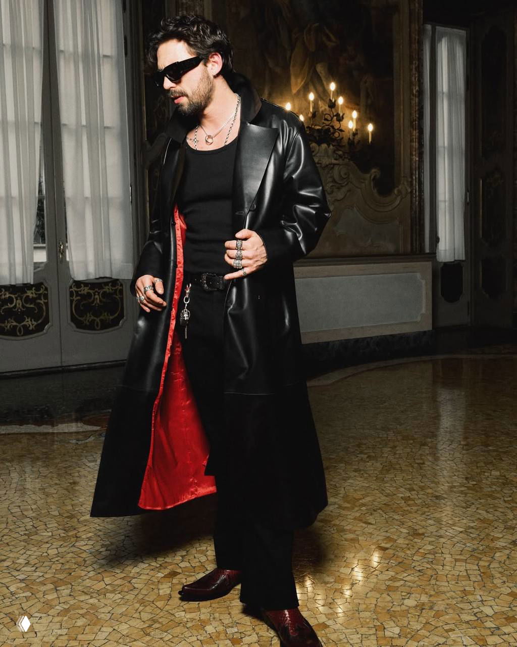 Таро в полном росте в длинном кожаном плаще с яркой красной подкладкой на фоне роскошного интерьера — кадр лукбука рекламной кампании KEIN и DESA.