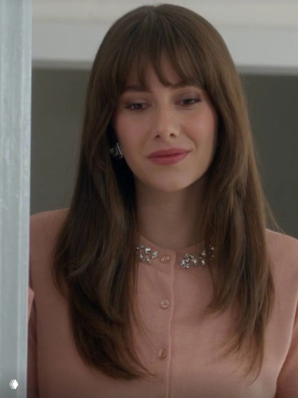 Крупный план Берил в пастельном кардигане с декором у воротника; мягкий макияж и спокойная палитра образа.