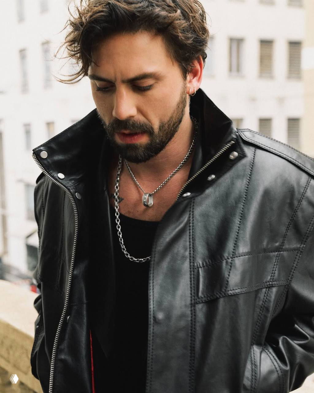 Крупный портрет Таро Эмира Текина в кожаной куртке и украшениях, задумчивый взгляд в промо-кадре рекламного проекта KEIN / DESA.