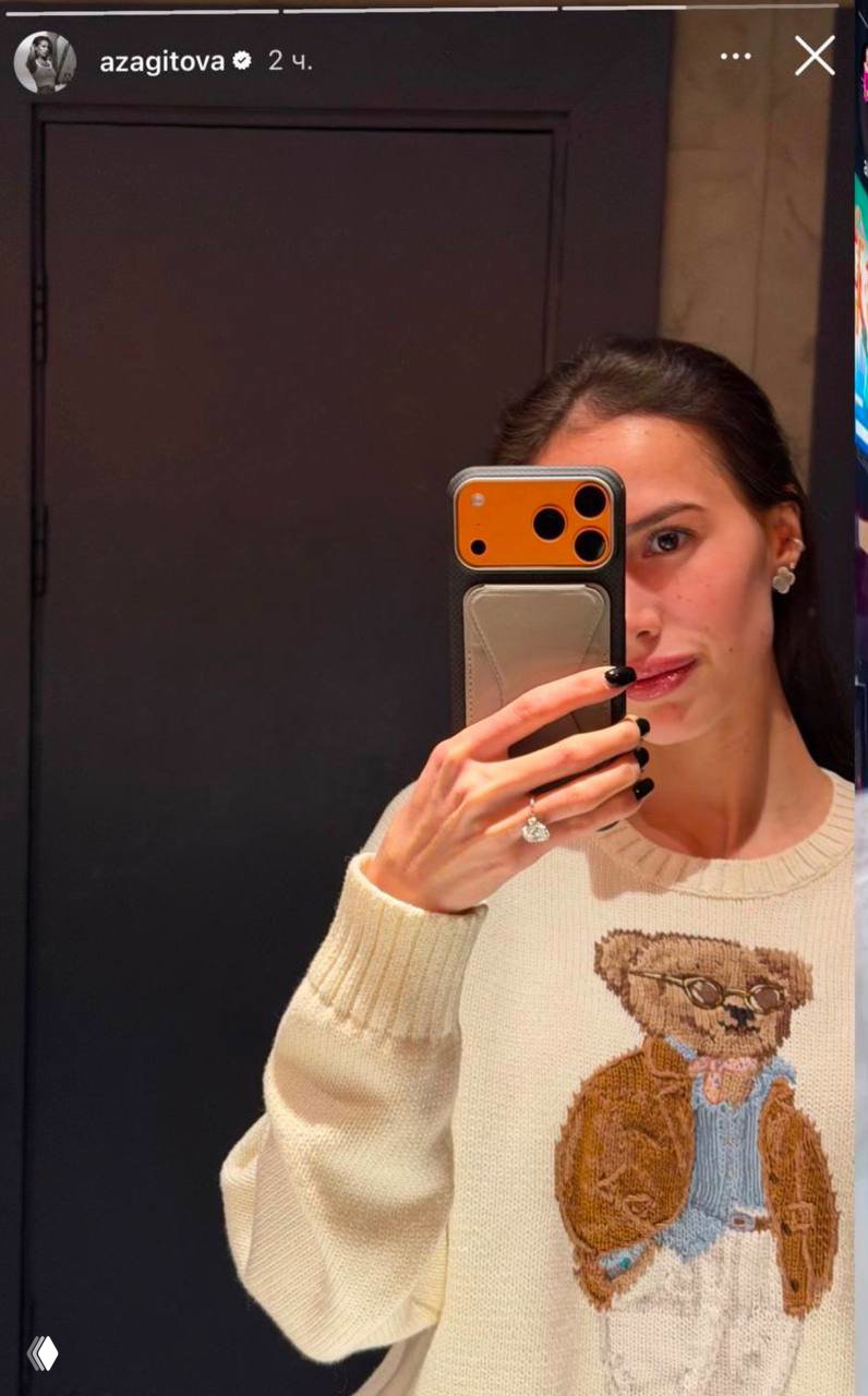 Зеркальное селфи Алины Загитовой в кофте с медвежонком: видна правая рука с заметным массивным кольцом на пальце