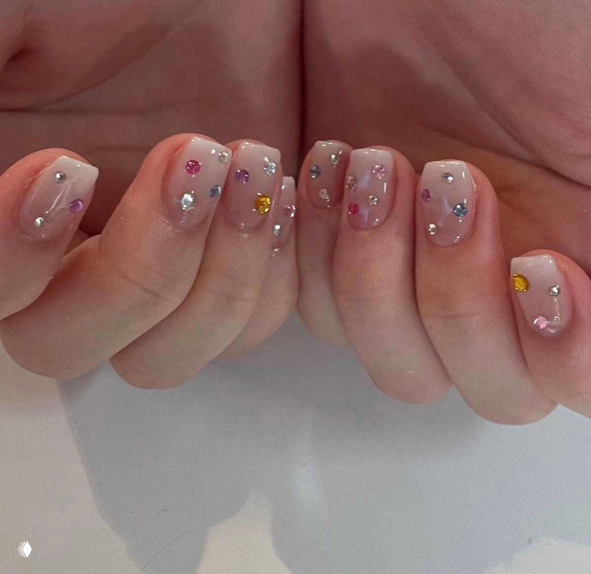 Сочетание нюдовой основы и разноцветных кристаллов разной формы и размера: разнообразие форм стразов на фото‑подборке трендовых идей.