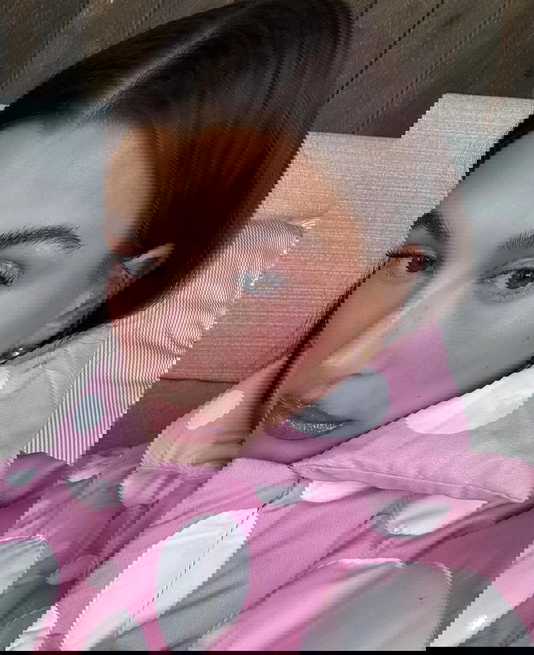 Крупный план лица с розовым румянцем, розово-золотыми тенями и блеском на губах — пример нежного макияжа с акцентом на сияние кожи.