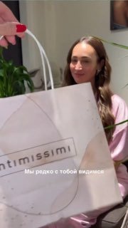 Кадр из видео: сестра Ани держит подарочный пакет Intimissimi, в коробочке оказались детские вещи — момент, когда Оля узнаёт о беременности.