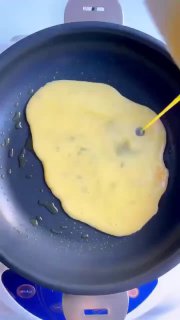 Сверху: сковорода с наливаемой яичной массой, начало жарки омлета/блинчика — кадр из простого рецепта завтрака.