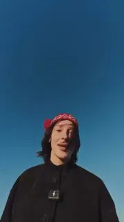 Вертикальный кадр женщины в повязке на голове на фоне чистого синего неба; сцена из короткого ролика в формате TikTok/соцсетей.