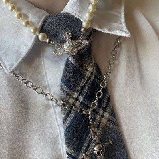 Деталь воротника, галстука и украшений в клетчатой гамме — комбинация цепочек и жемчуга для создания эстетики Фрэнки из Monster High.