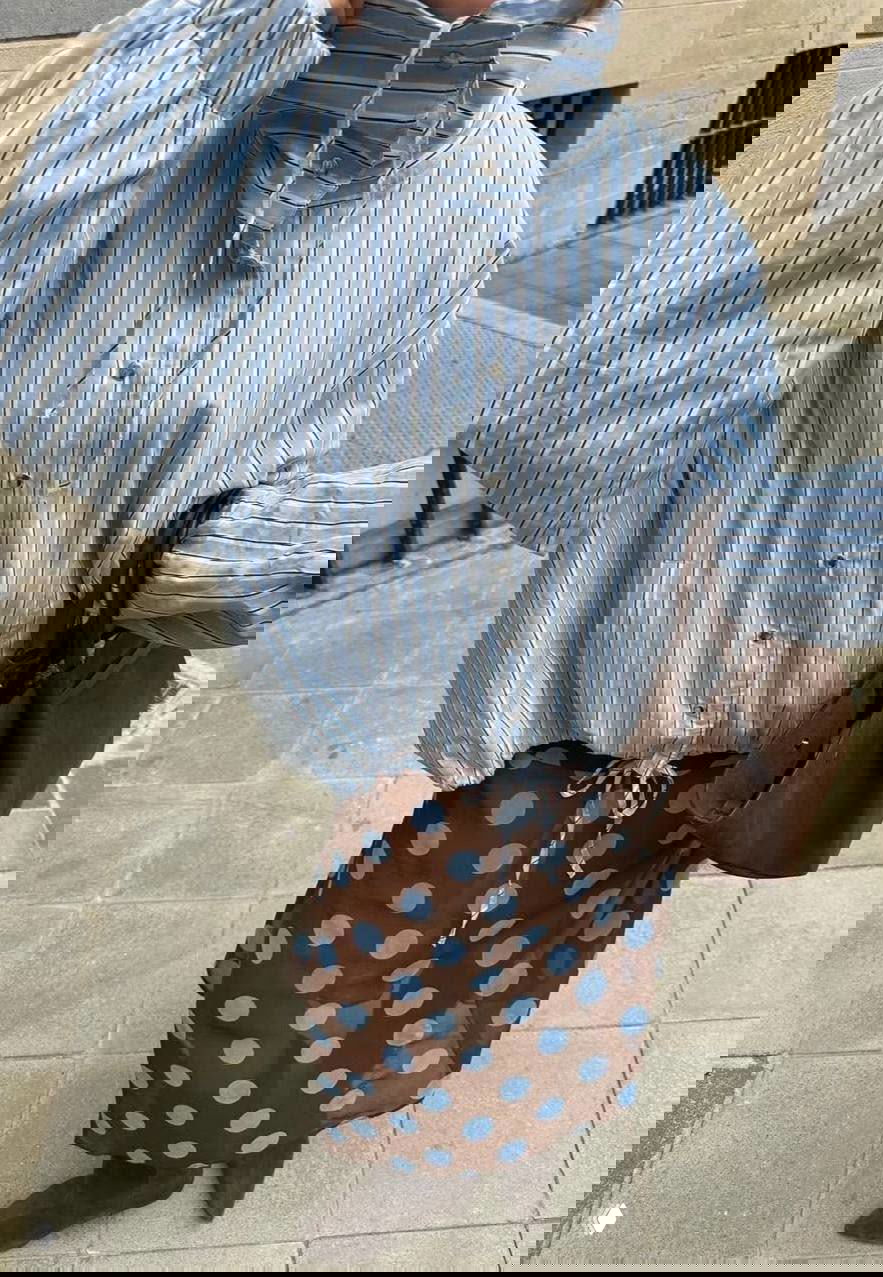 Уличный образ: голубая полосатая блуза в сочетании с коричневой юбкой в крупный горох и коричневыми аксессуарами.