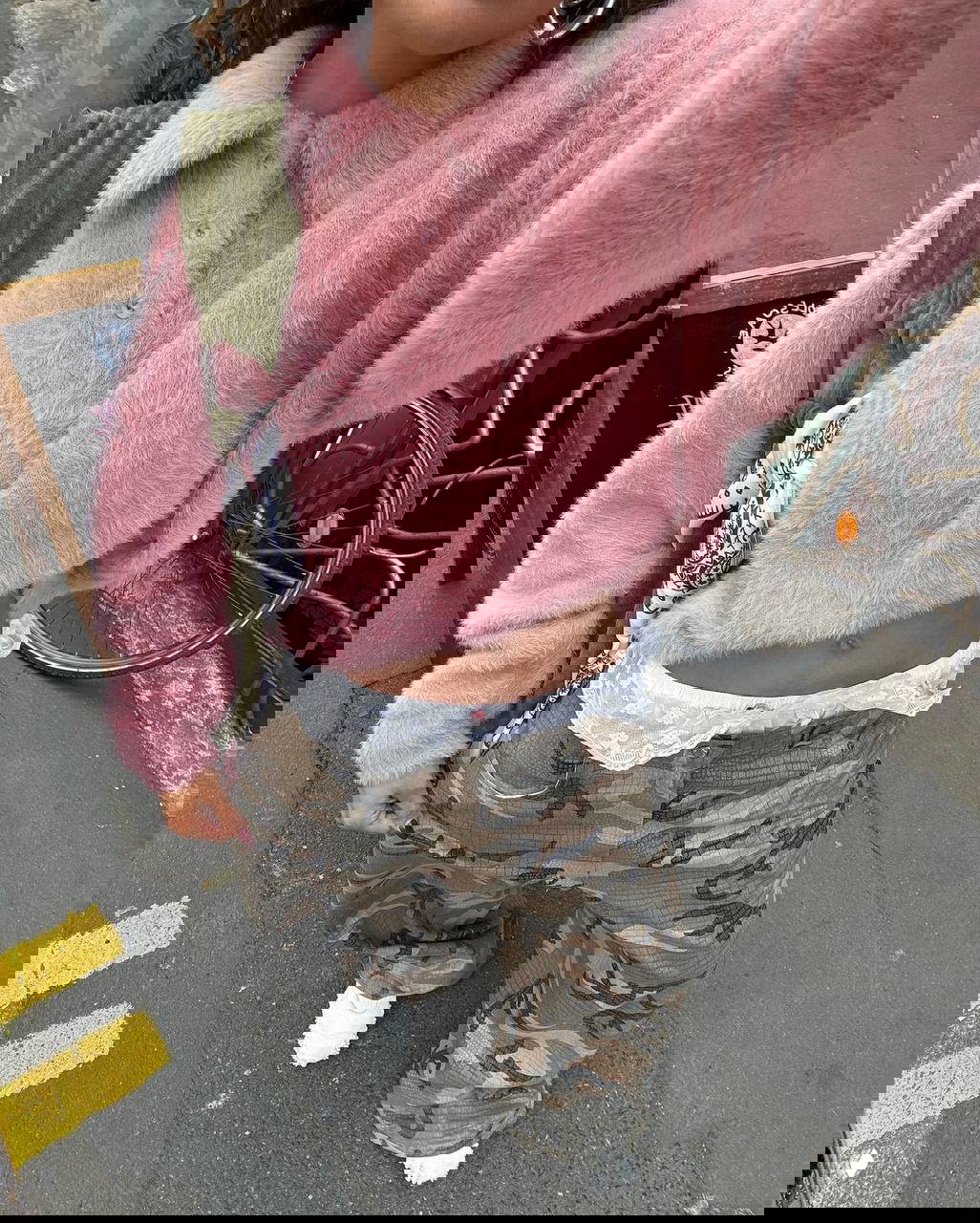 Крупный кадр: розовая пушистая кофта с камуфляжными карго‑брюками и кружевной деталью — контраст текстур в уличном образе.